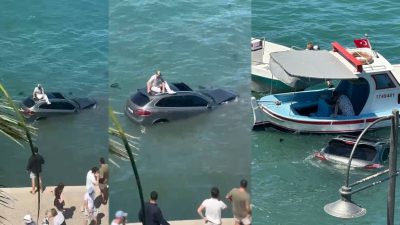 Balıkesir'in Ayvalık ilçesinde sürücüsü denizin içinde batmakta olan otomobilin üzerinde